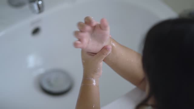 Little-girl-washing-her-hands-to-prevent-virus-and-germs-indoor.