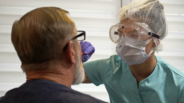 Krankenhausmitarbeiter-nimmt-Patientenabstrich,-um-auf-Coronavirus-zu-testen