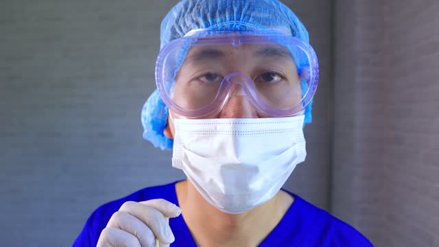 Asiatische-männliche-medizinische-Arbeiter-in-Ppe-Uniform-und-Gesichtsmaske-arbeiten-im-Krankenhaus-Diagnose-und-Untersuchung-Covid-19-Patienten.-Junge-Krankenschwester,-die-eine-Nasenabstrichprobe-nimmt,-um-auf-Corona-Virus-Infektion-zu-testen