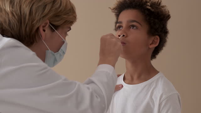 Praktizierende-Ärztin-nimmt-PCr-Test-Nasenabstrich-von-kleinem-Patienten