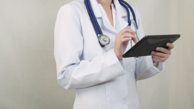 The-doctor-in-a-white-coat-working-with-the-tablet