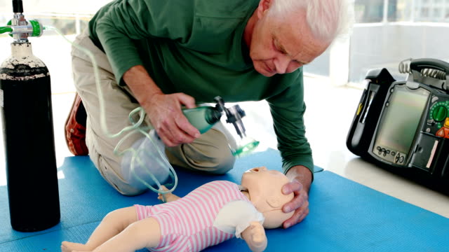 Männliche-Sanitäter-geben-Sauerstoff-eine-Puppe