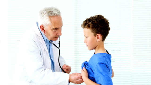 Hombre-médico-examinando-a-un-niño