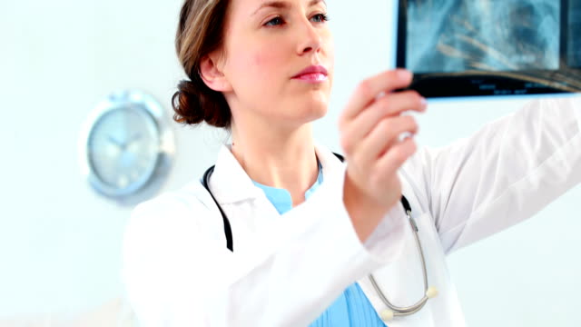 Mujeres-médico-examinar-un-informe-de-rayos-x