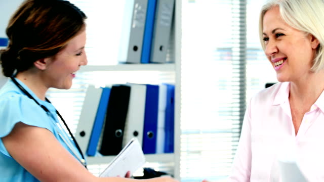 Female-doctor-giving-a-medical-prescription-to-a-patient