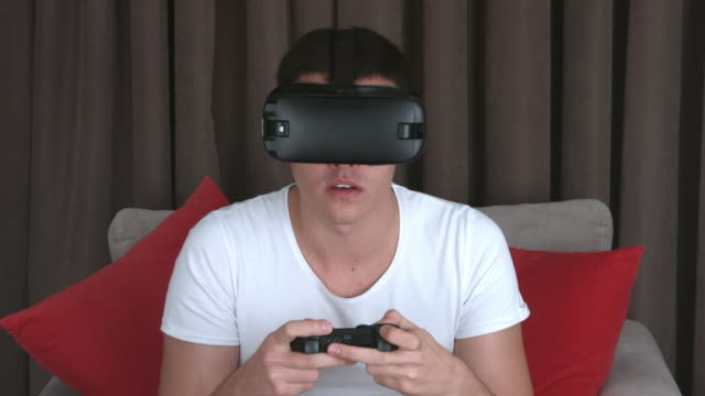 Junger-Mann-tragen-VR-Kopfhörer-und-Virtual-Reality-Spiele-zu-Hause-spielen