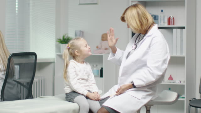 Female-Doctor-Does-Throat-Examination-of-a-Little-Girl.-After-Examination-They-Do-High-Five.