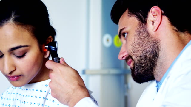 Arzt-untersuchen-Patienten-Ohr-mit-Ohrenspiegel