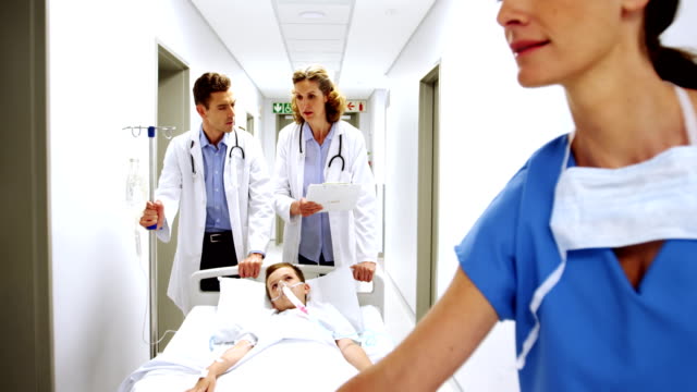 Doctores-empujando-la-cama-Camilla-emergencia-en-corredor