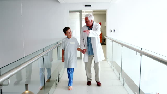 Doctor-interactuando-con-el-paciente-caminando-en-el-pasillo