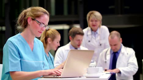 Krankenschwester-mit-Laptop-im-Konferenzraum