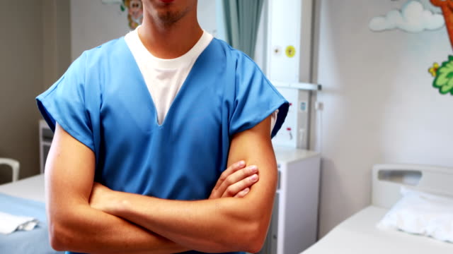 Doctor-standing-with-arms-crossed-in-hospital