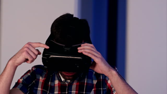 Junger-Mann-zieht-vr-Brille-an-und-genießt-Virtual-Reality-Welt