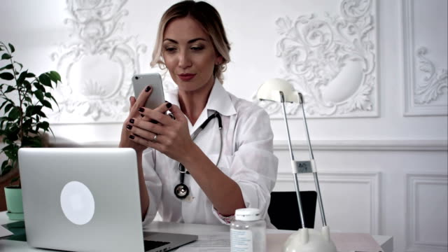 Smiling-female-doctor-making-selfie-on-her-smart-phone