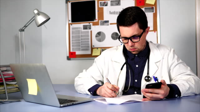 Asistente-médico-que-trabaja-en-el-lugar-de-trabajo-con-smartphone-y-formularios-médicos.