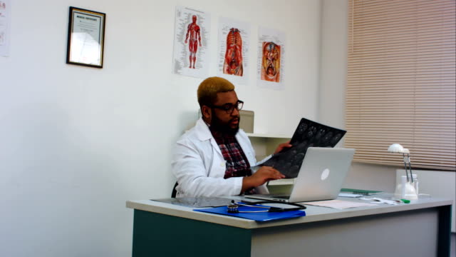 Doctor-masculino-discutiendo-imagen-de-radiografía-cerebral-con-el-paciente-en-Skype