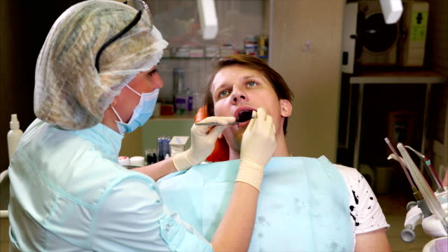 Arzt-Zahnarzt-führt-eine-primäre-Untersuchung-der-Mundhöhle-des-Patienten