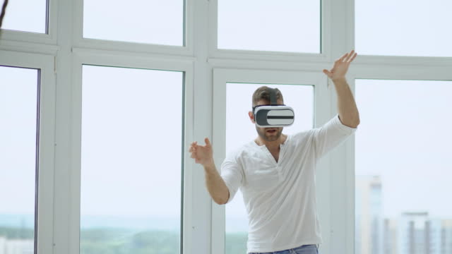 Young-man-have-VR-experience-with-virtual-reality-headset-using-hands-gestures-for-control