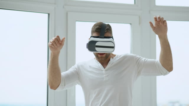 Junger-Mann-haben-VR-Erlebnis-mit-virtual-Reality-Kopfhörer-mit-Händen-Gesten-zur-Steuerung