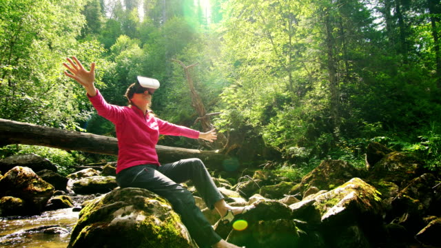Woman-in-a-pair-in-VR-glasses-on-the-background-of-a-mountain-river