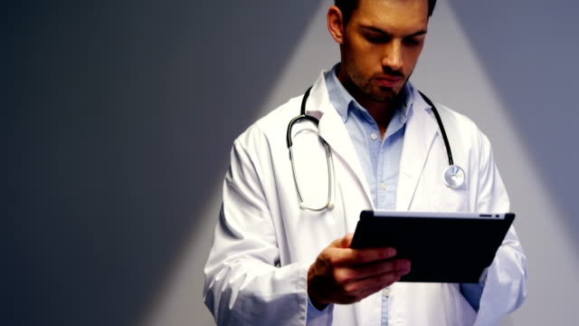 Doctor-using-digital-tablet-in-corridor