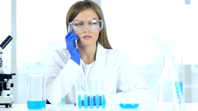 Female-Scientist-Talking-on-Phone-in-Laboratory