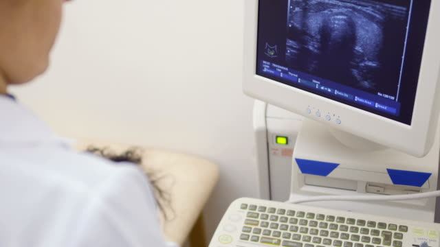 Doctor-looks-at-screen-of-ultrasound-machine