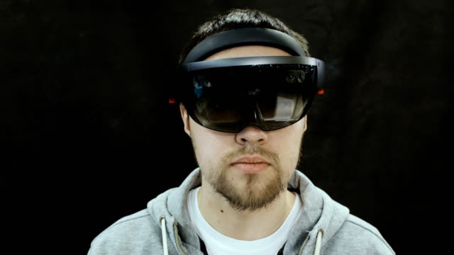 Augmented-Reality-Brille.-Junge-Erwachsene-kaukasischen-Mann-mit-holographischen-augmented-Reality-Brille.-Spiele-Entwicklung