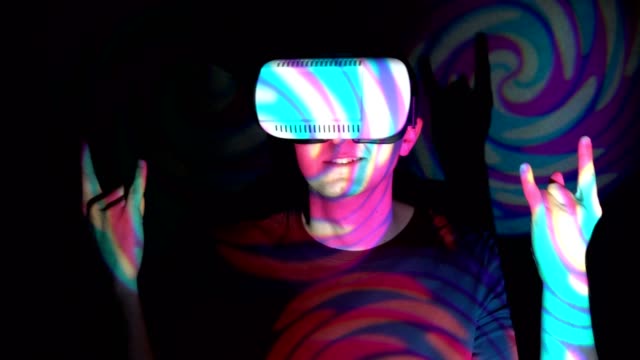 Joven-de-gafas-de-realidad-virtual-haciendo-señal-de-cuernos-con-los-dedos