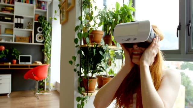 Frau-mit-virtual-Reality-Kopfhörer-im-Wohnzimmer-4k