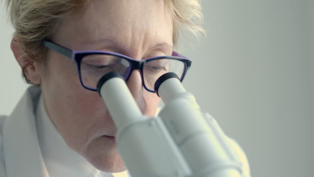 Weibliche-Wissenschaftler-auf-der-Suche-durch-Mikroskop