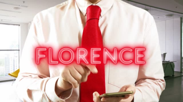 Florence.-Businessman-operating-a-smart-device-chooses-а-city-on-light-background.-Concept:-business-trip,hologram,-technology,-augmented-reality,-future,-travel
