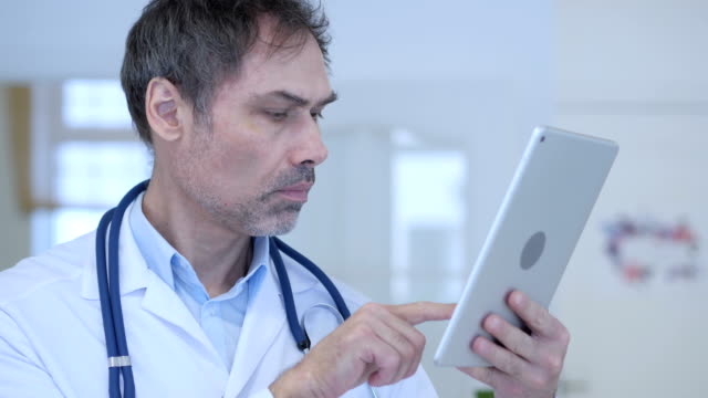 Doctor-using-Tablet-Pc-for-Online-Browsing