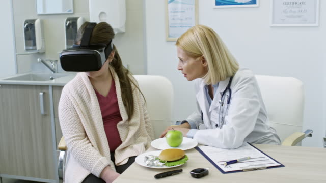 Arzt-im-Gespräch-mit-Mädchen-in-VR-Kopfhörer