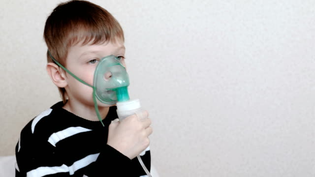 Vernebler-und-Inhalator-für-die-Behandlung-zu-verwenden.-Junge-durch-Inhalator-Maske-Einatmen.-Seitenansicht.