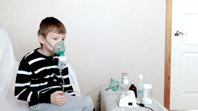 Utilice-el-nebulizador-y-el-inhalador-para-el-tratamiento.-Niño-de-inhalar-a-través-de-mascarilla-inhalador.-Vista-lateral