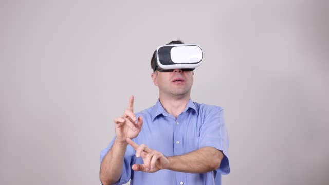 Man-wearing-virtual-reality-goggles-on-grey