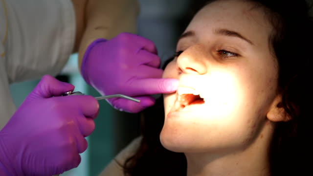 Zahnarzt-macht-Professionelle-Zahnreinigung-junge-Patientin-in-der-zahnärztlichen-Praxis