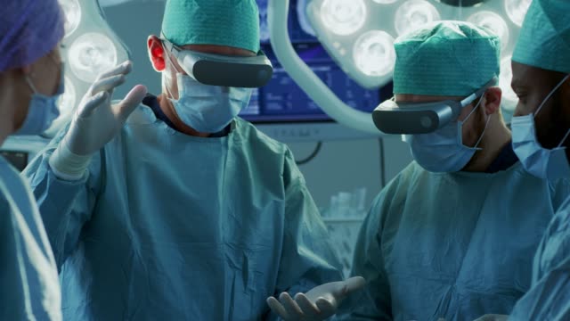 Surgeons-Wearing-Augmented-Reality-Glasses-Perform-State-of-the-Art-Augmented-Reality-Surgery-in-High-Tech-Hospital.-Doctors-and-Assistants-Working-in-Operating-Room.