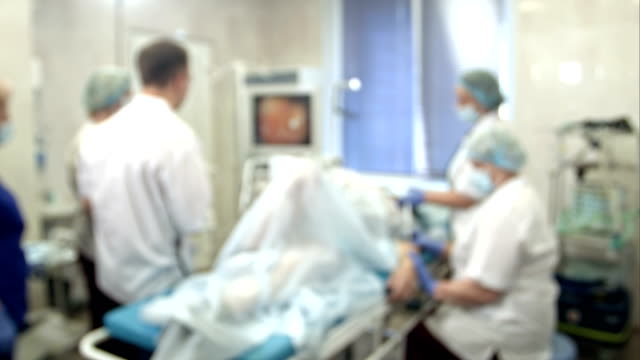Doctors-and-nurses-performing-endoscopic-procedure-in-hospital