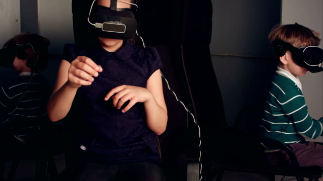 Three-little-kids-in-vr-headsets-enjoying-virtual-reality-game