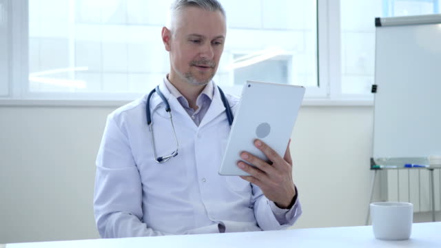 Online-Video-Chat-auf-Tablet-von-Arzt