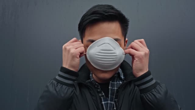 hombre-asiático-usando-máscara-protectora-en-gris