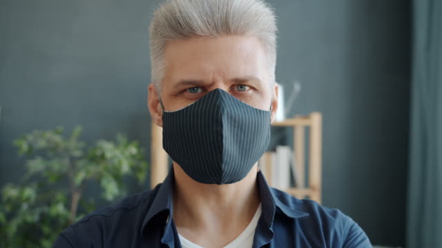 Nahaufnahme-Porträt-von-erwachsenen-Mann-trägt-Multi-Use-handgefertigte-Maske-zu-Hause