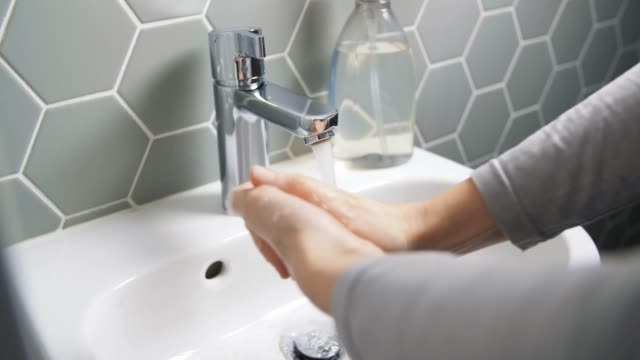 de-cerca-de-la-mujer-lavando-las-manos-con-jabón-líquido