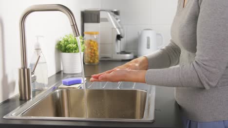 Frau-waschen-Hände-mit-Flüssigseife-in-der-Küche
