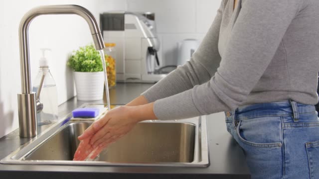 Frau-waschen-Hände-mit-Flüssigseife-in-der-Küche