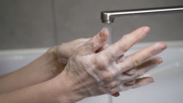 mujer-lavando-sus-manos-correctamente-con-un-montón-de-jabón-en-su-fregadero-de-casa-sin-desperdiciar-agua