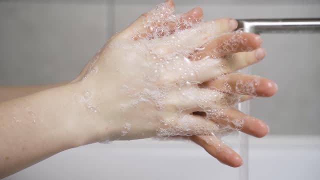 woman-washing-her-hands-properly-with-plenty-of-soap-in-her-home-sink-without-wasting-water
