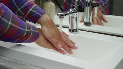 Hände-unter-einem-Wasserhahn-waschen,-eine-Person-wäscht-den-Schmutz-von-seinen-Händen-weg,-Schutz-vor-Coronavirus-Infektion,-Händedesinfektion
